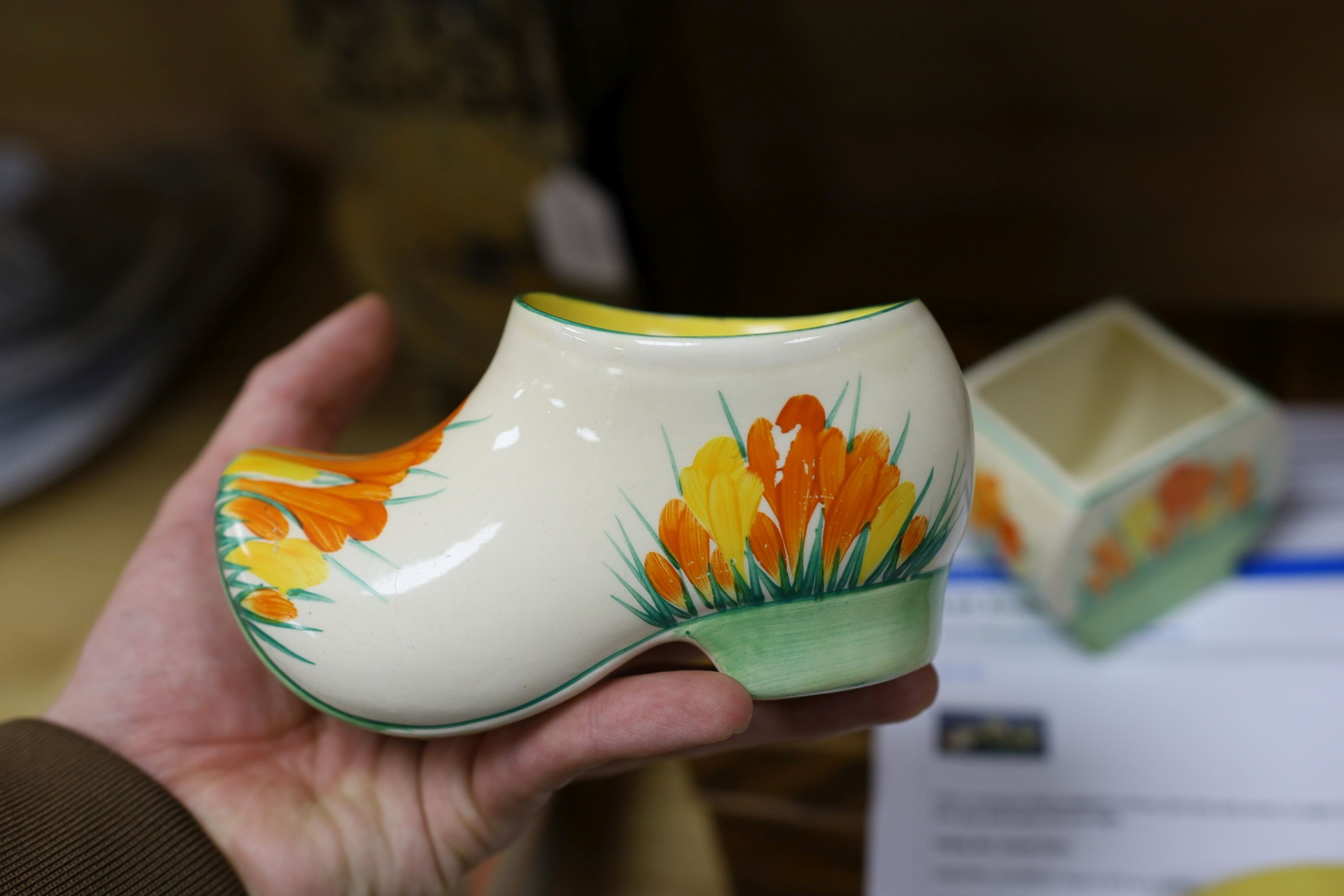 A Clarice Cliff sungleam crocus jam pot and cover, a sugar shaker and a Dutch clog ornament (3), jam pot and cover 10 cms high